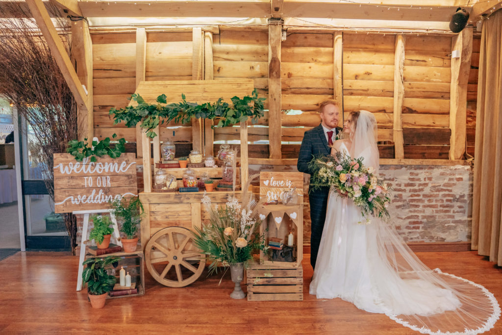 bride and groom stood with sweet cart, wedding